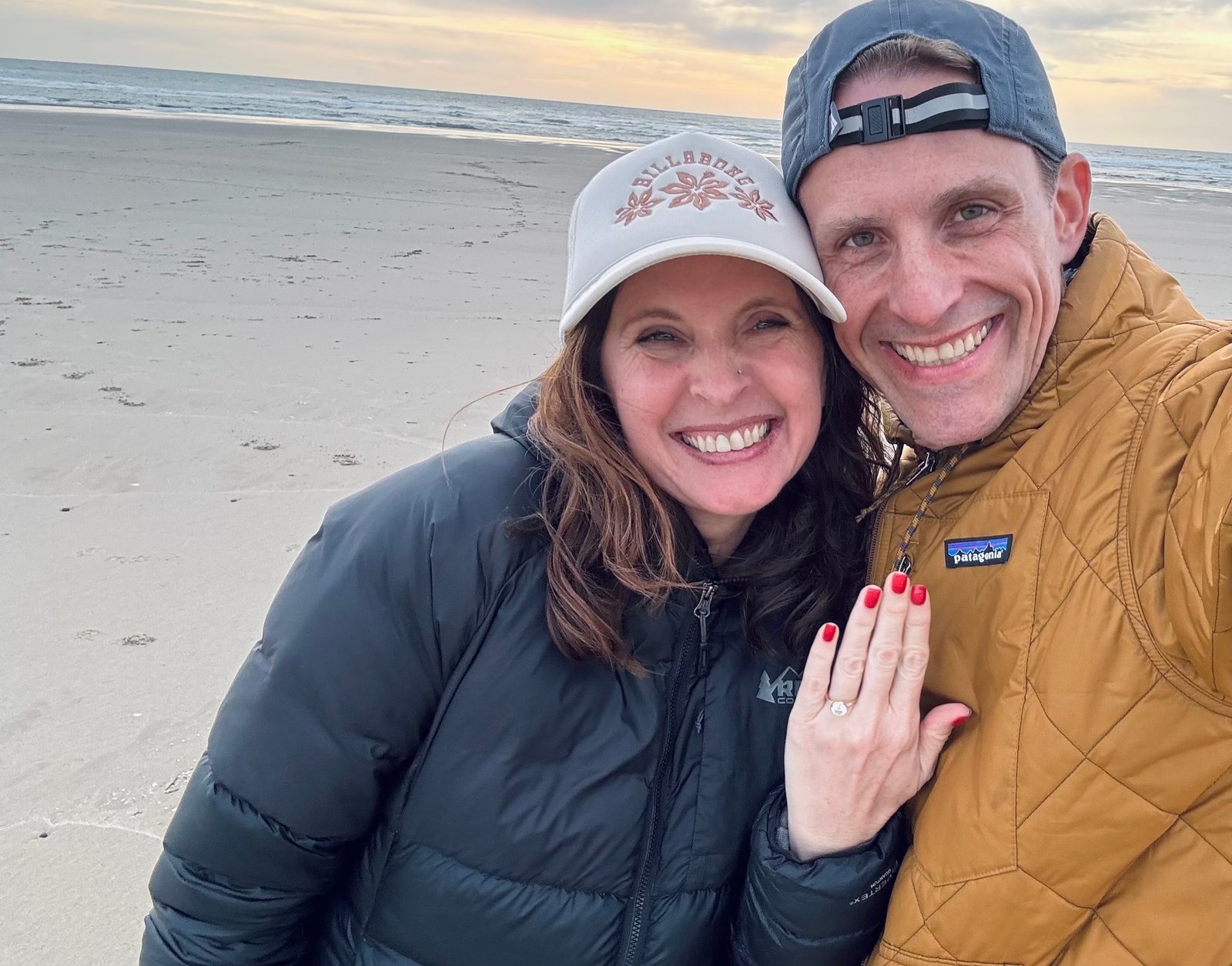 Jarod and Rachel smiling together and showing Rachel's engagement ring
