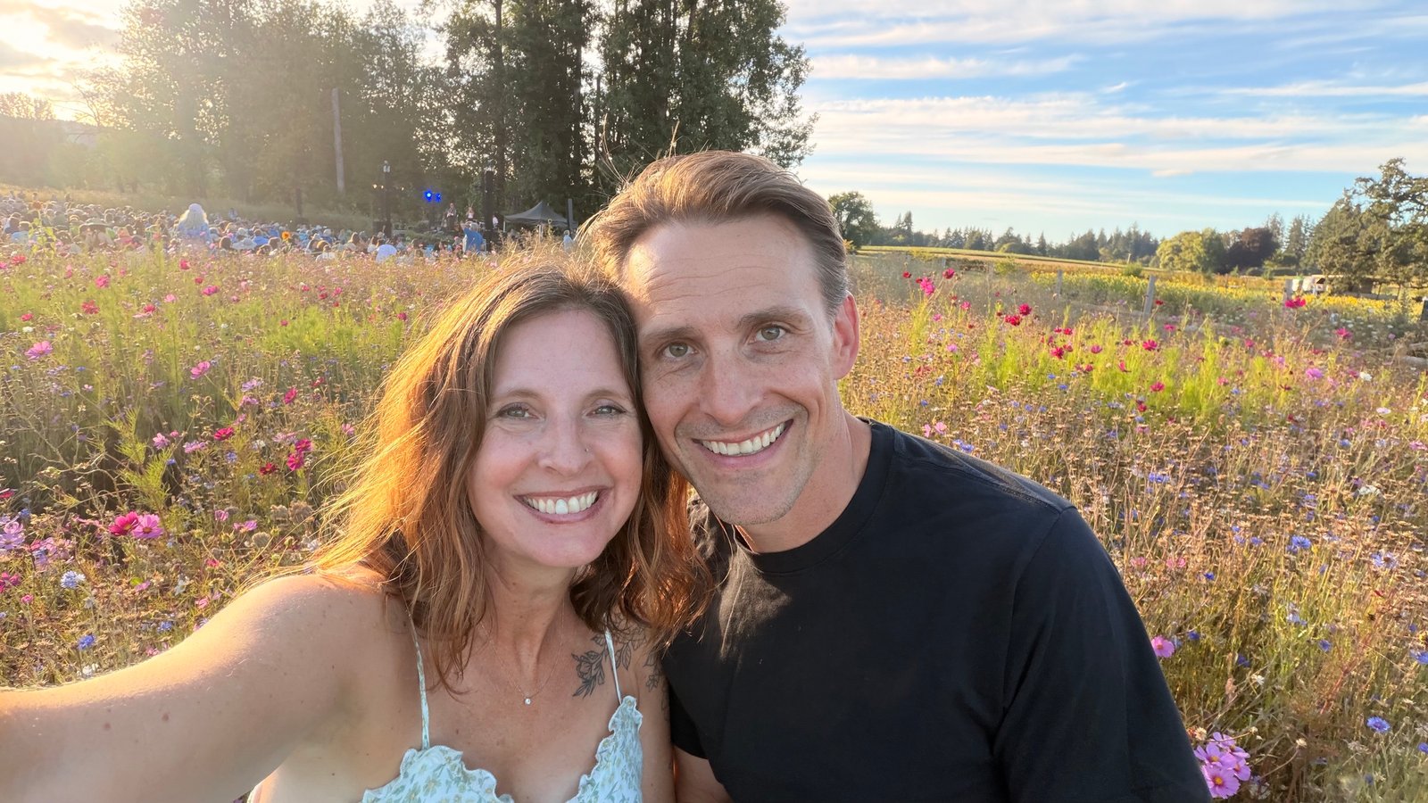 Jarod and Rachel smiling together in a field of flowers